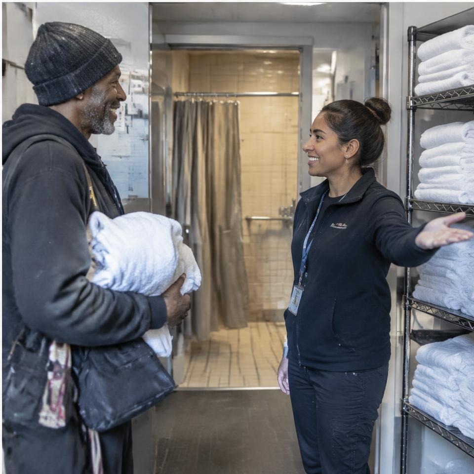 Volunteer welcoming a guest to a community shower facility