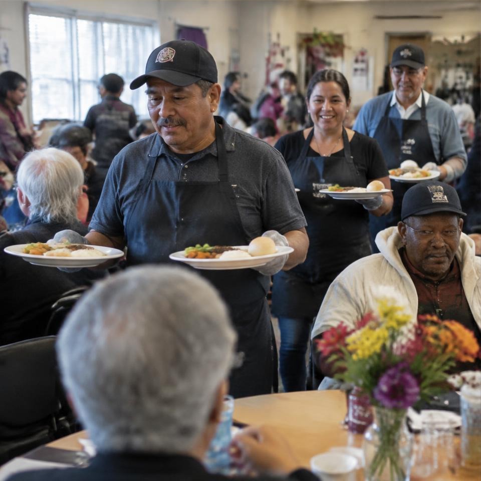 Volunteers delivering meals to neighbors in a dining room